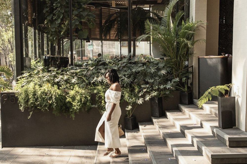 Arrival — Planting, stone and shade at the entrance.